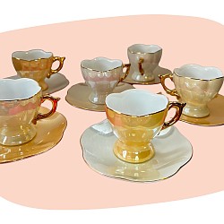 service à café, Geneviève Lethu, porcelaine nacrée, reflets irisés, anses dorées à la main, vaisselle vintage, style années 80, design raffiné, élégance intemporelle, ensemble 12 pièces, décoration féminine, art de la table, concept store, les filles les meufs, garrigues sainte Eulalie, uzes service tasse nacrée geneviève lethu sous-tasse pastel jaune blanc doré
