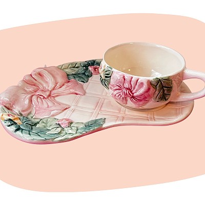 tasse et assiette, faïence émaillée, barbotine, décor fleuri, ruban rose, peinture à la main, vaisselle vintage, style romantique, nuance pastel, duo thé rétro, charme ancien, décoration poétique, concept store, les filles les meufs, garrigues sainte Eulalie, uzes