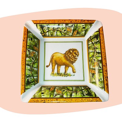 vide-poche en porcelaine, cendrier décoratif, lion peint à la main, motif tropical, porcelaine fine, style safari chic, décoration exotique, liseré doré, vert et or, objet artisanal, déco élégante, esprit jungle, pièce raffinée, concept store, les filles les meufs, garrigues sainte Eulalie, uzes